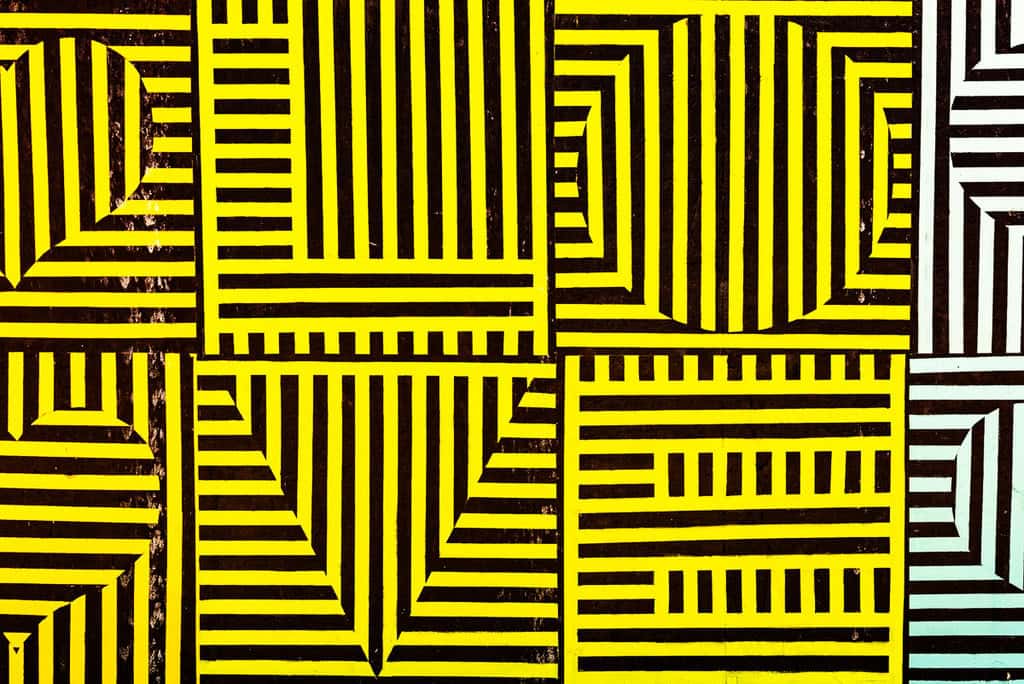 Abstract graffiti with yellow and black geometric patterns.