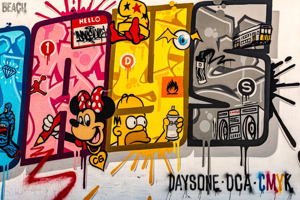 Street art featuring Minnie Mouse and Homer Simpson with vibrant colors.