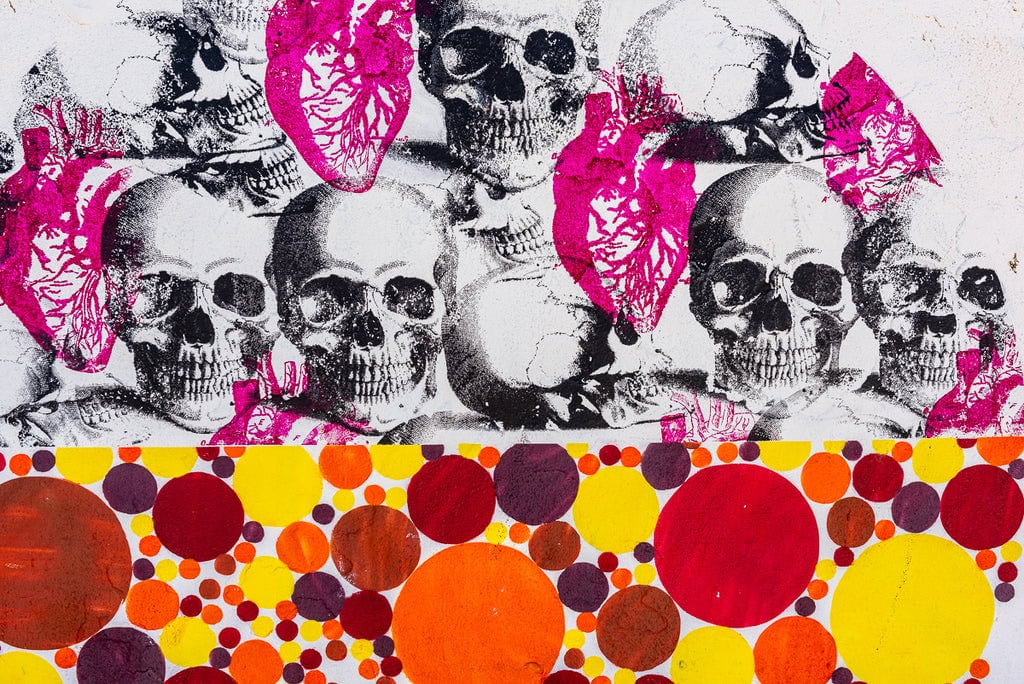 Graffiti mural featuring skulls and hearts in black and pink.