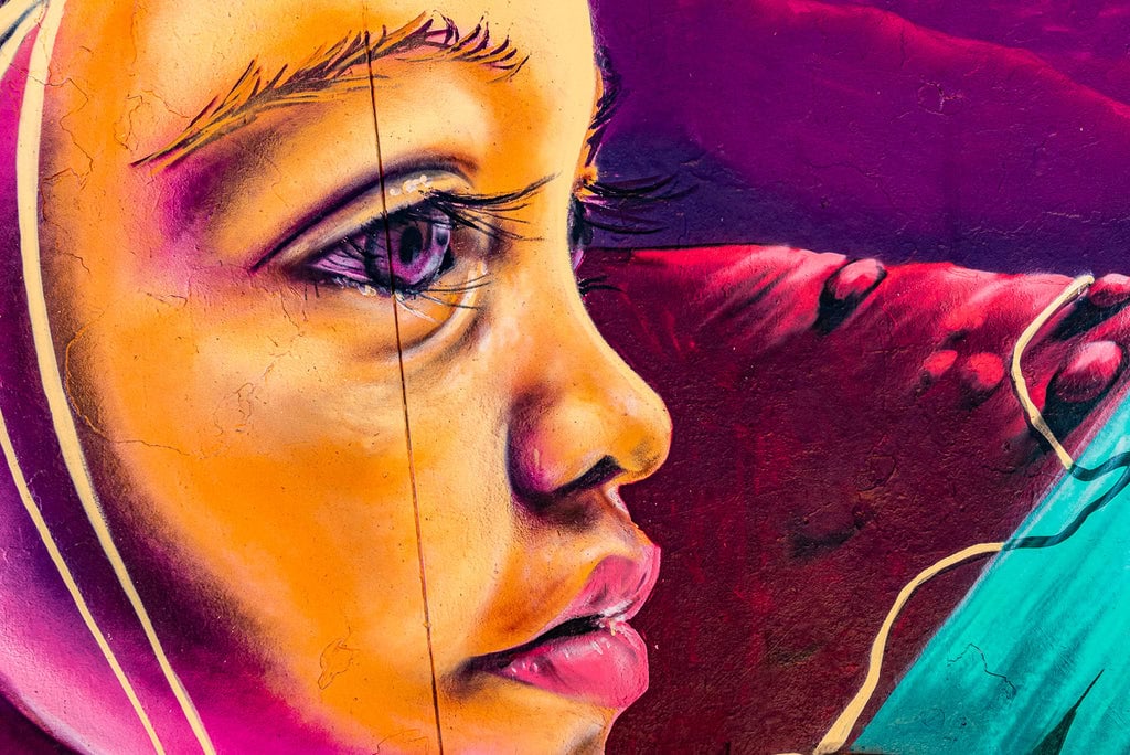 Close-up of a child’s face in graffiti art with vivid colors.