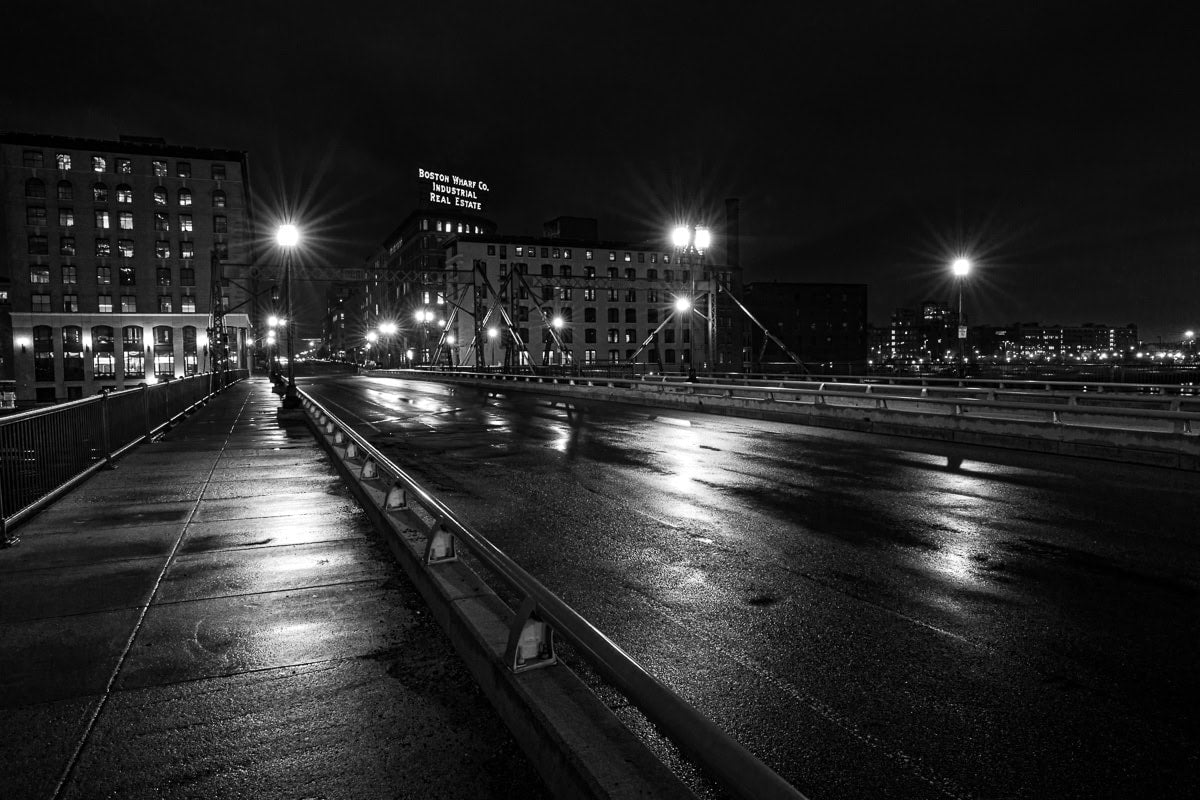 An iconic Boston sign illuminated in quiet after rainfall.