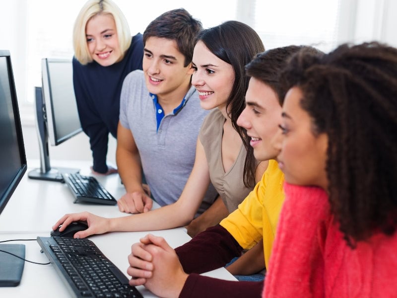 Crowds of people looking at a computer monitor