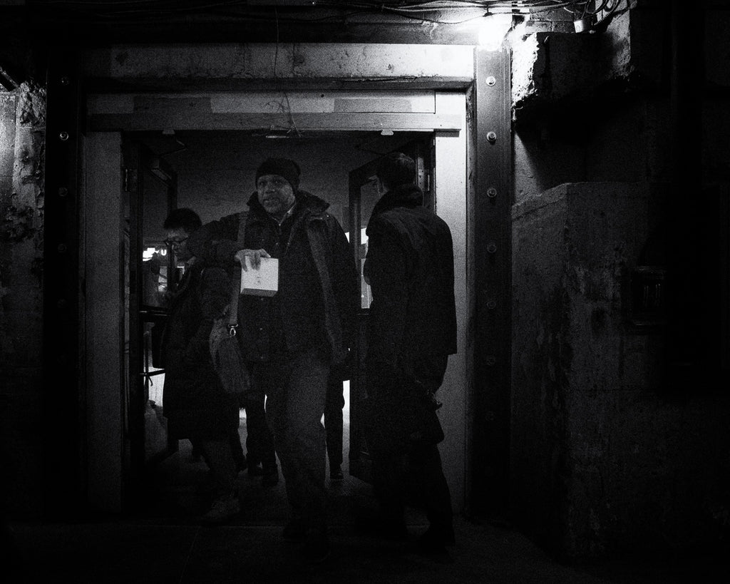 Man holding a small box stares at me as he enters the dark passage in Toronto’s Union Station
