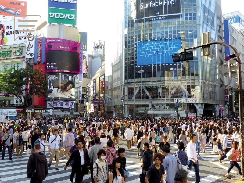 A busy day at Shibuya Crossing, Tokyo, where hundreds of pedestrians flood the intersection, creating an iconic scene of city life.