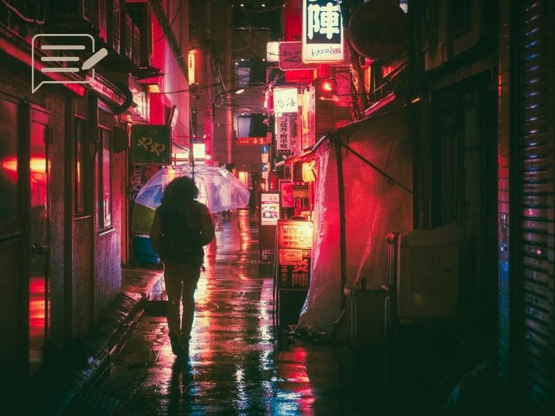 A lone figure walking through a neon-lit alley in Tokyo, carrying an umbrella under the soft glow of rain-soaked streets.